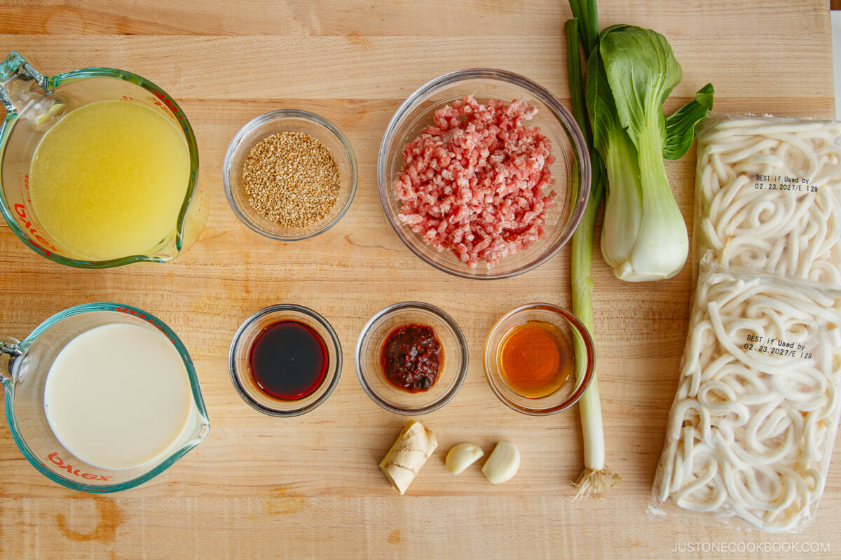  chicken broth, sesame seeds, ground pork, bok choy, udon noodles, milk, soy sauce, chili paste, sesame oil, ginger, garlic, and green onion.