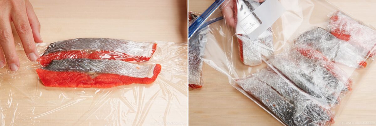 Salted salmon fillets prepared for Japanese Shiozake, wrapped in plastic wrap on a wooden surface.