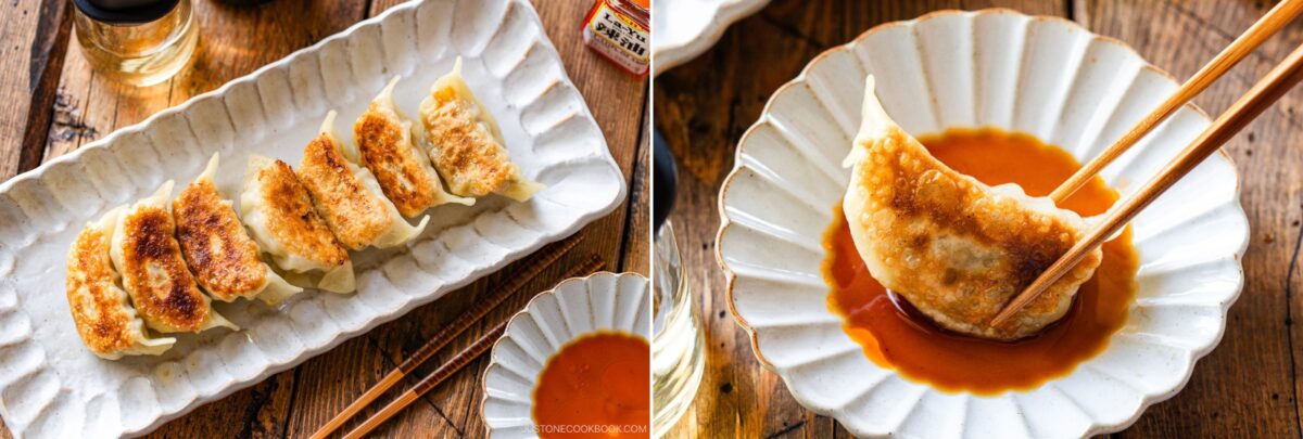 A plate of six golden-brown pan-fried dumplings, made from a classic Gyoza Recipe, sits next to a small dish of dipping sauce; on the right, chopsticks hold one dipped dumpling, all on a wooden table.